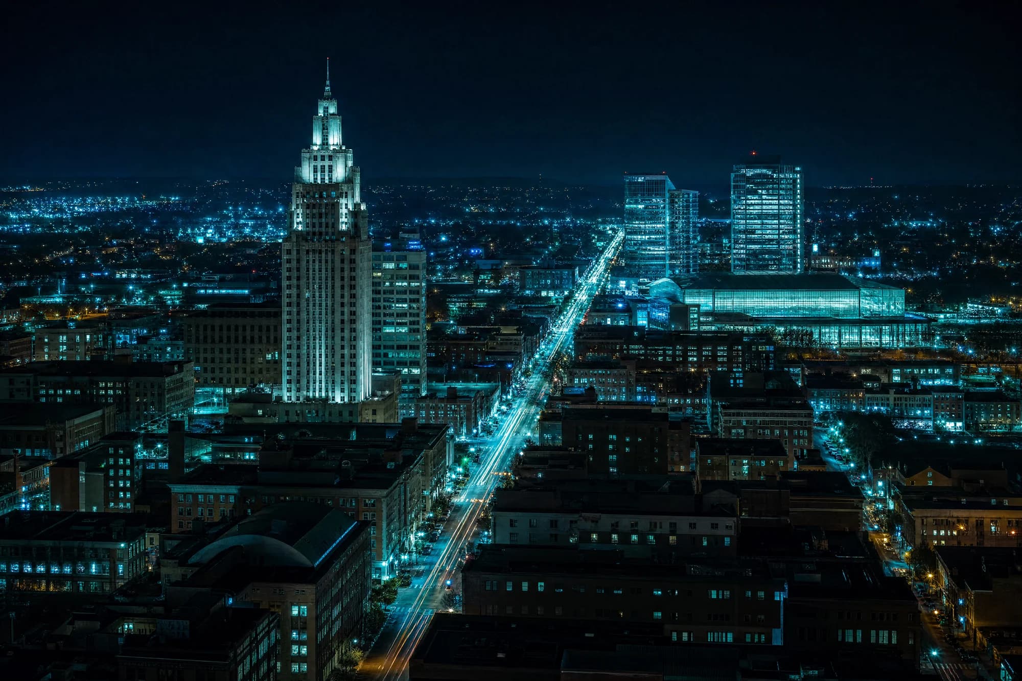 Stylized night render of downtown Allentown with the PPL tower and Hamilton Street lit in teal