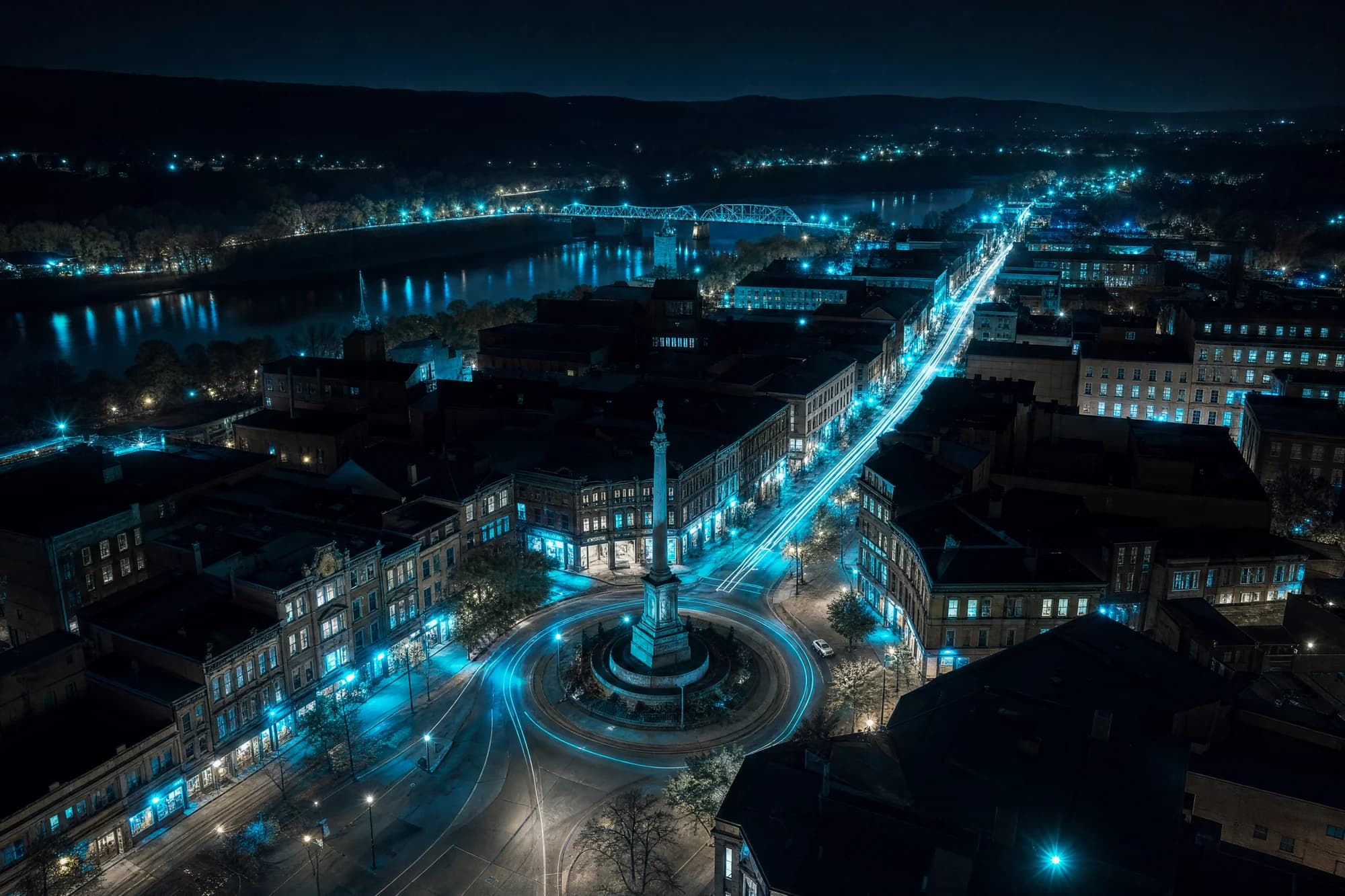 Stylized night render of Easton's Centre Square and the free bridge lit in teal
