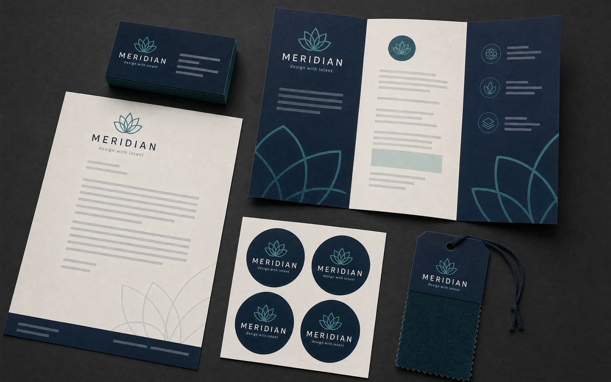 Staged photograph of printed brand collateral sharing one navy and teal identity.